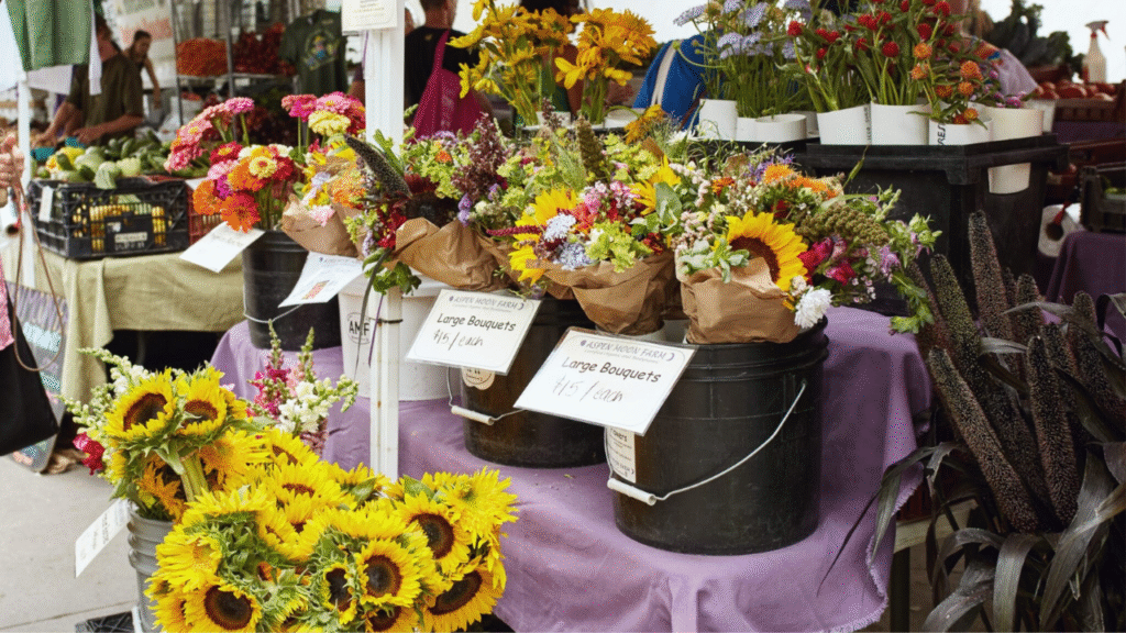 Florist choosing fresh, high-profit cut flowers at local farmers market”