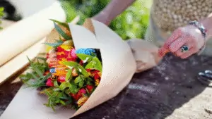 Local flower grower arranging a mixed bouquet of profitable flowers for direct sale at farmers market